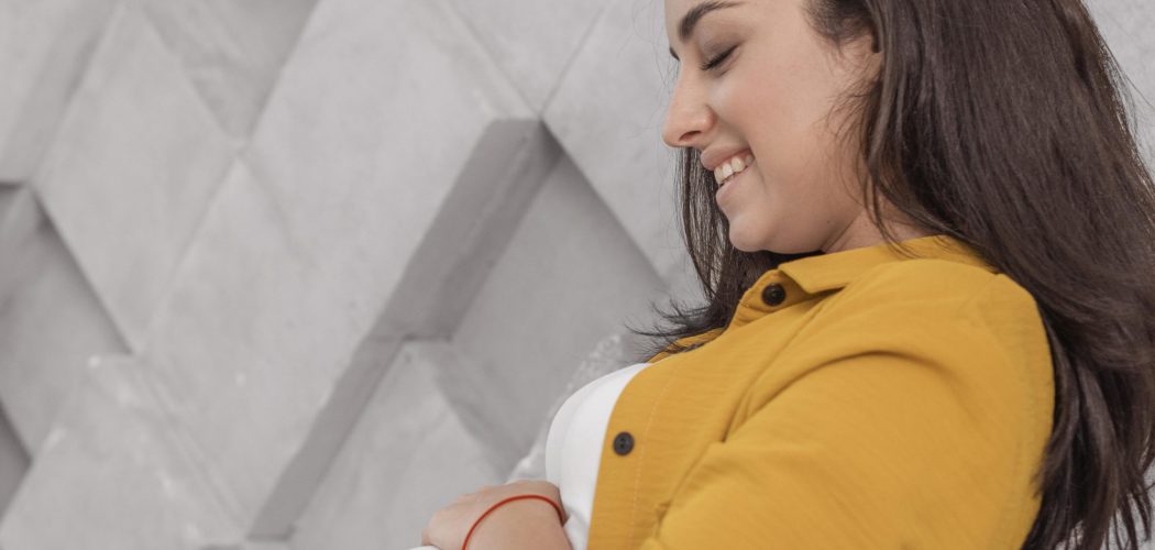 smiley-pregnant-woman-home-embracing-her-belly
