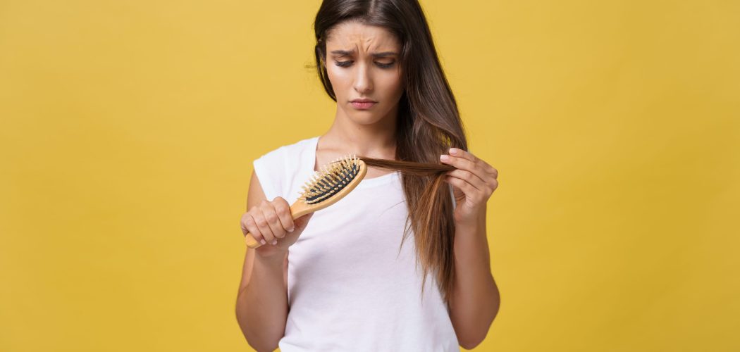 Woman hand holding her long hair with looking at damaged splitting ends of hair care problems